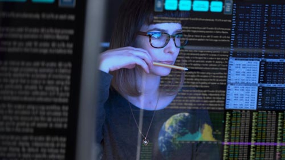 Woman looking at code on a computer screen