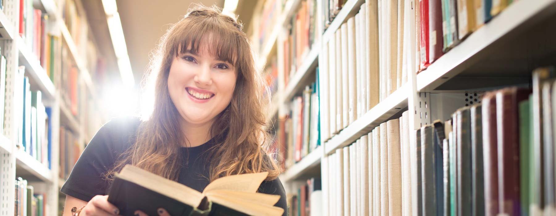 Creative writing student reading in library