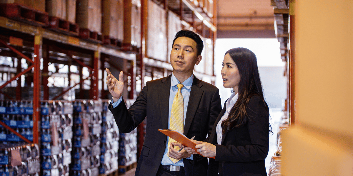 Two logistics professionals talking in a warehouse