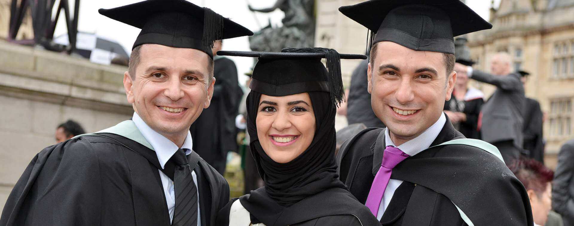 Group of three graduates in robes