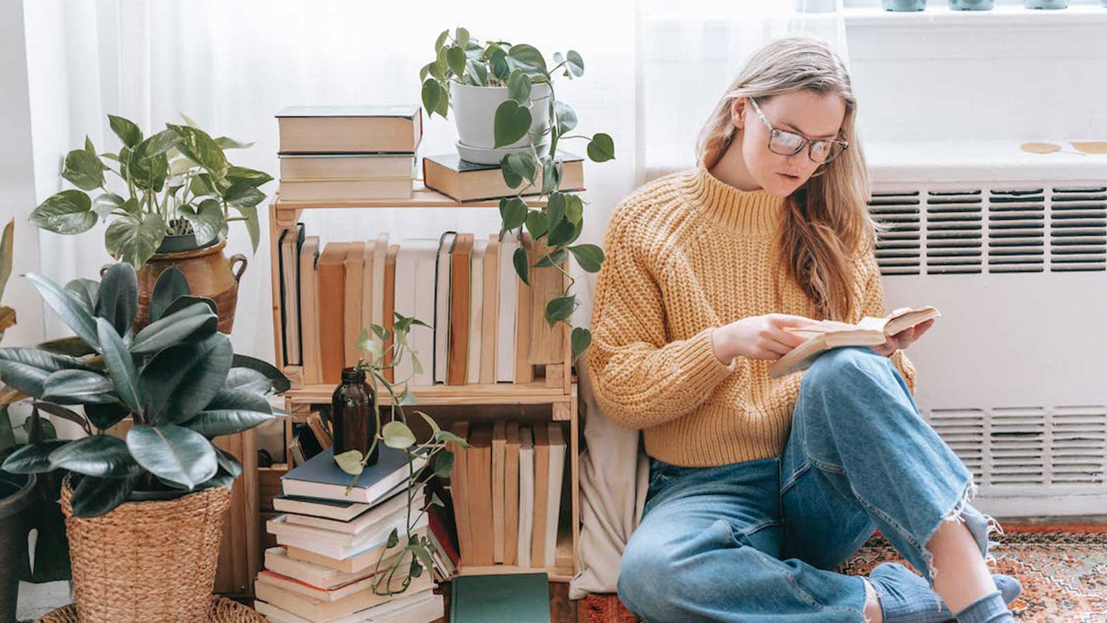 Creative Writing student reading next to a bookcase