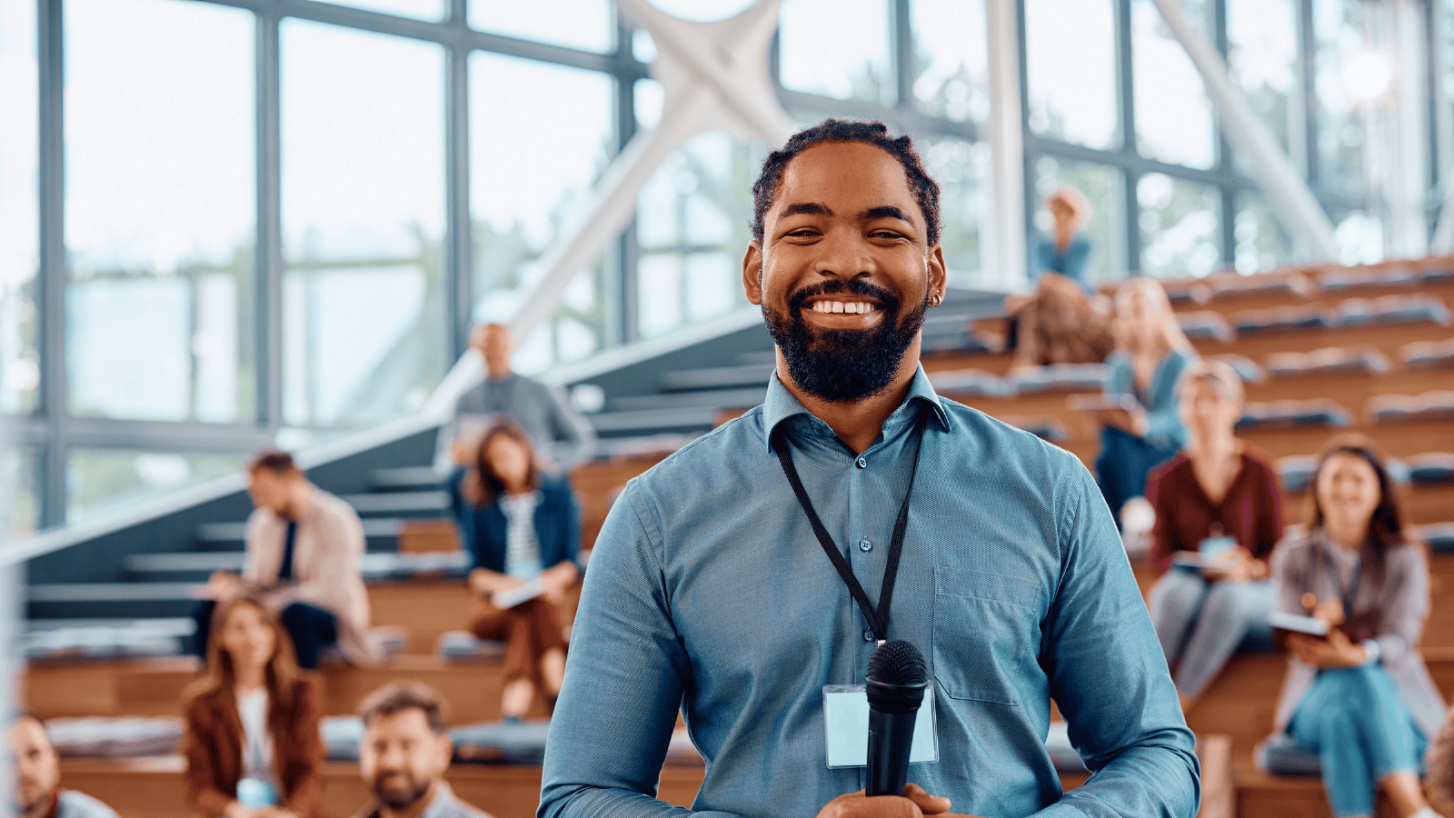 Smiling male educator standing in lecture hall