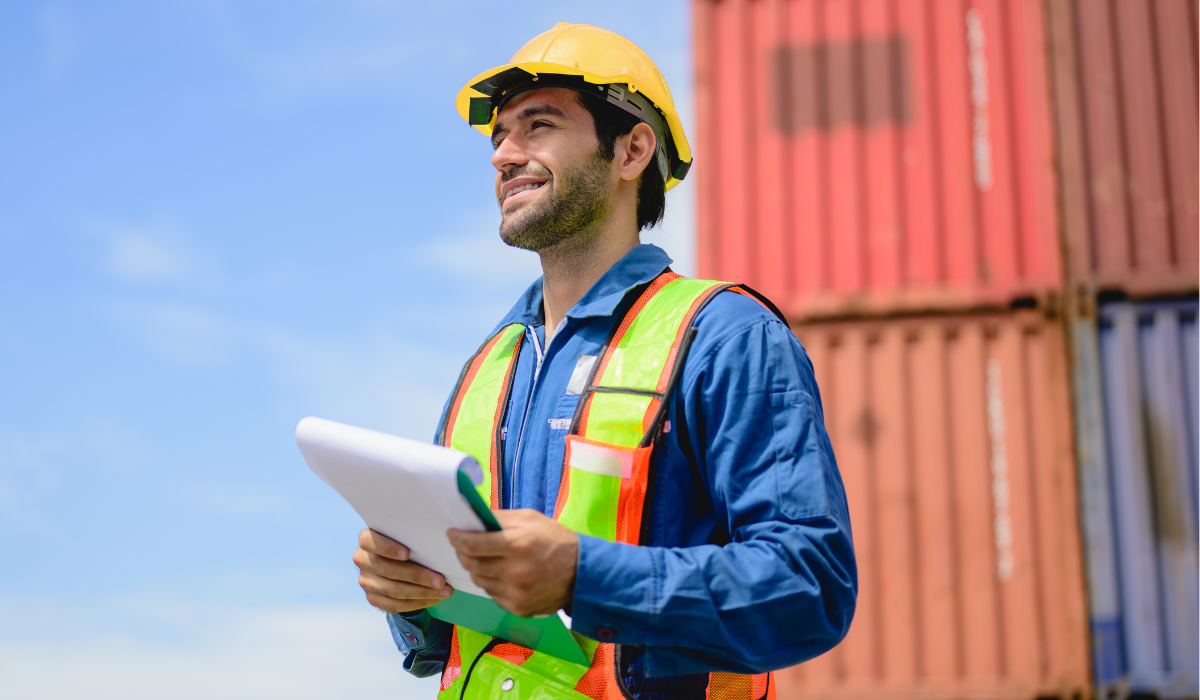 Logistics professional standing near shipping containers